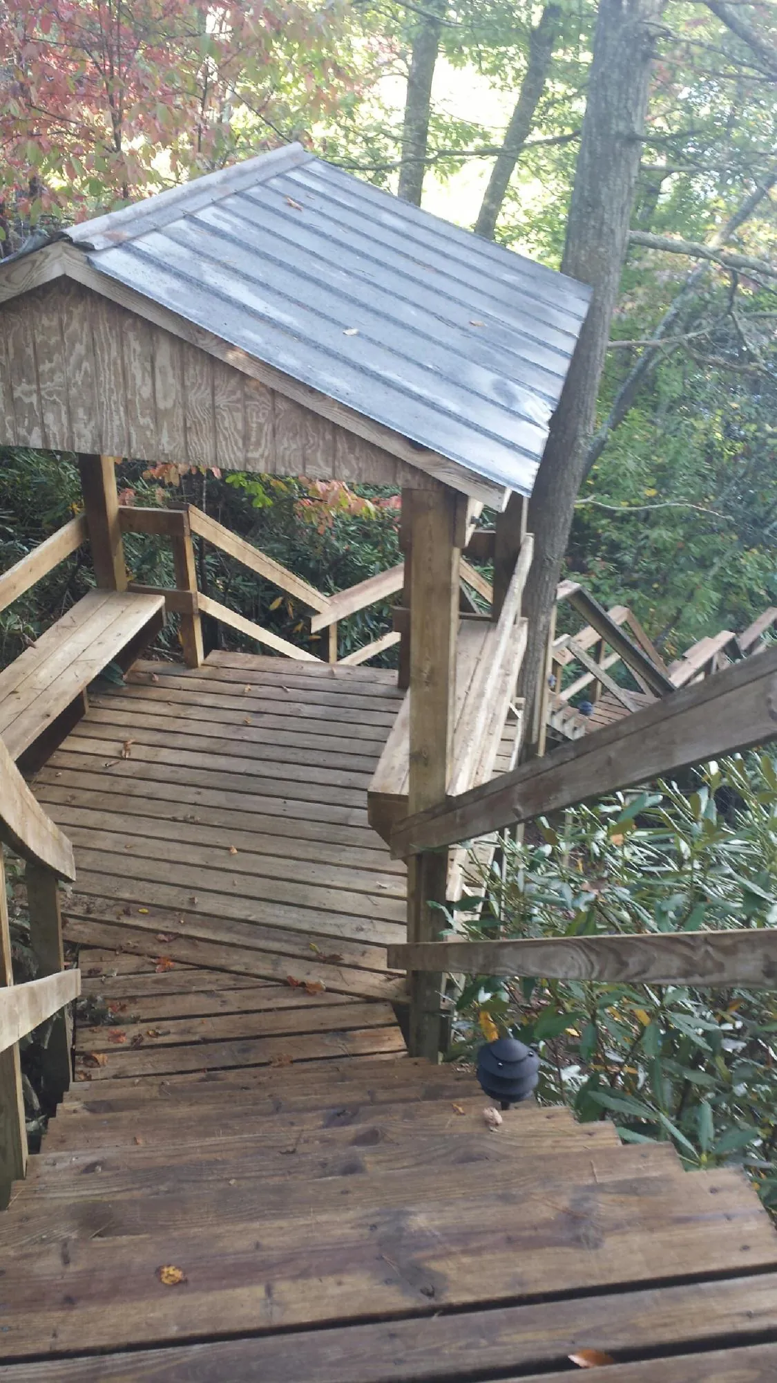Metal roofed shelter over wooden steps on a wooded walkway — Skylight Repair & Installation work by our crew in Osceola Mills