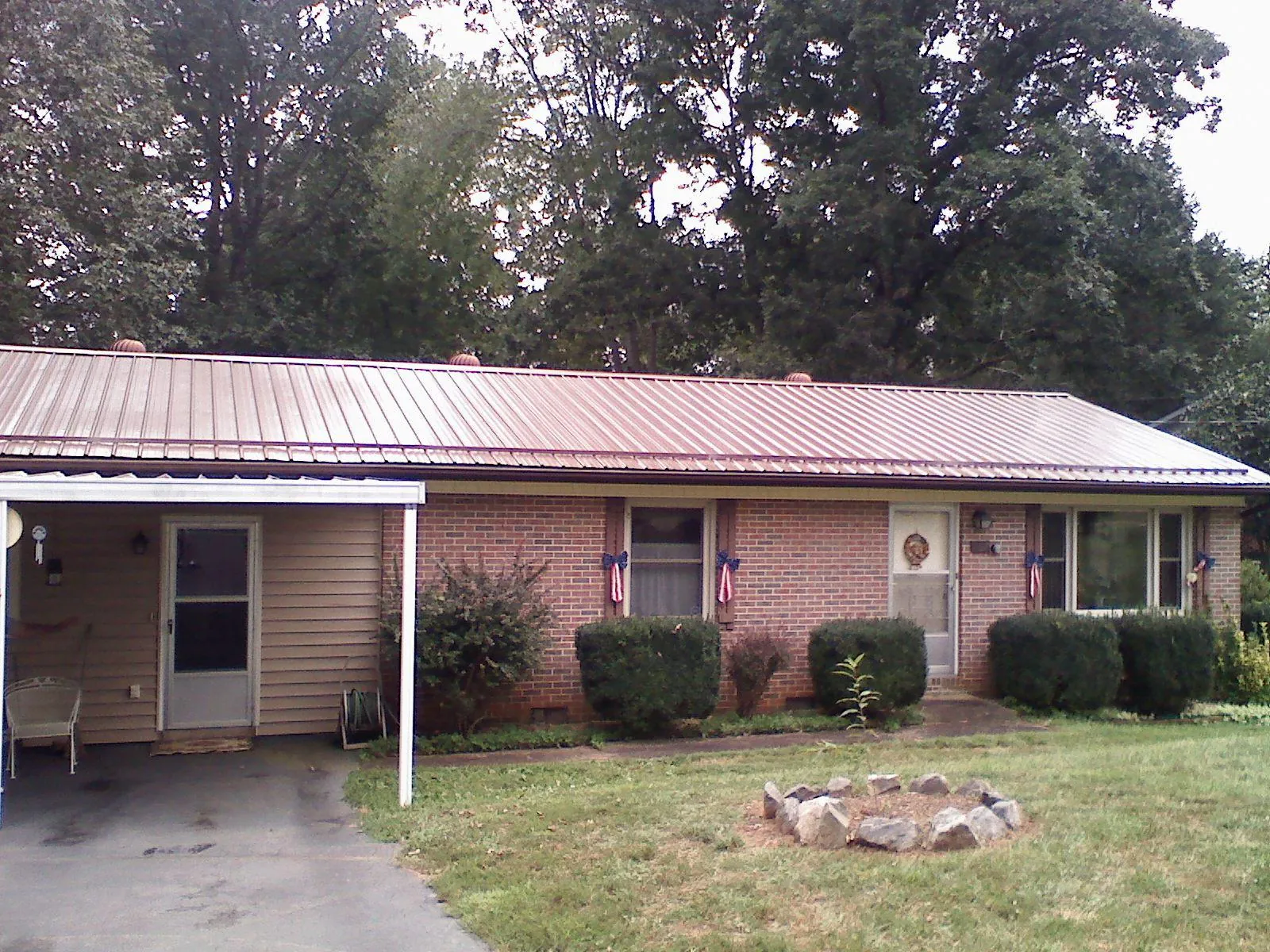 Bronze metal roof and carport on a brick ranch home — Roof Repair work by our crew in Osceola Mills
